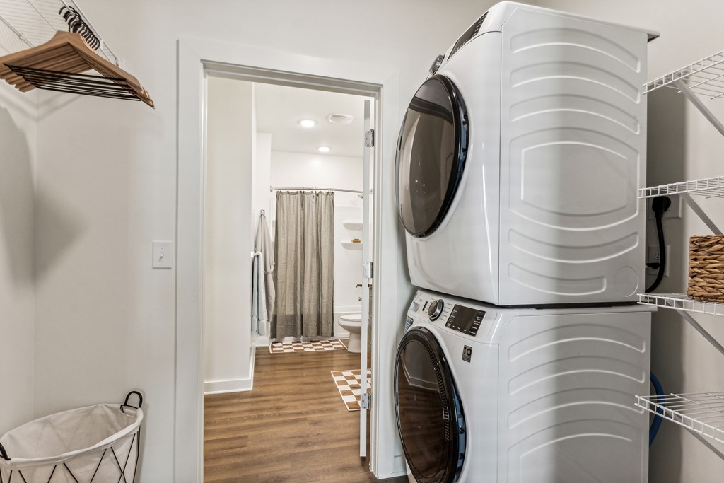 a washer and dryer in a laundry room with a door to a bathroom
